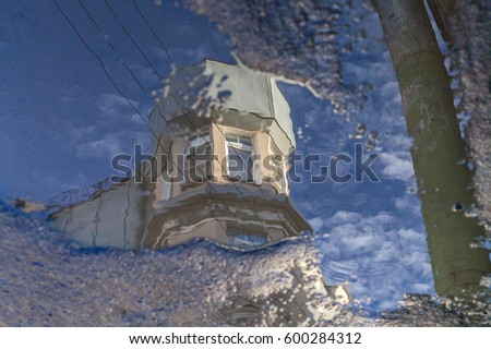Puddle reflection of vintage building tower