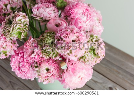 pink persian buttercup flowers. Curly peony ranunculus in green vintage can, copy space.
