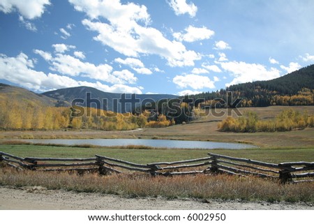 A beautiful mountain meadow with a lake or pond during autumn aspen yellow leaves