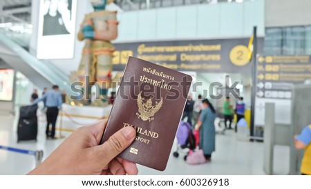 Hand that show the thailand passport at suwannaphum airport. Royalty-Free Stock Photo #600326918