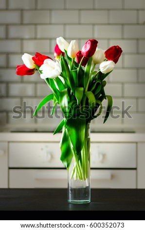Fresh white and red tulips on kitchen background. Present from husband, man. Copyspace