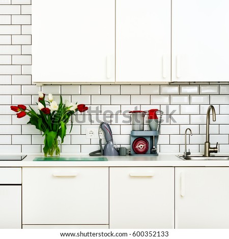 Fresh bouquet of red and white tulips on kitchen table. Detail of home interior, design. Minimalistic concept. Flowers for mother, girl, woman. Copy space