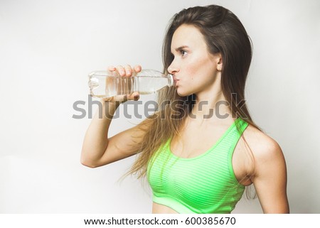 Happy sporty teen woman with bottle water drinks