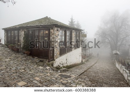 Fog and traditional stone building in Vizitsa village on mountain Pelion.Greece