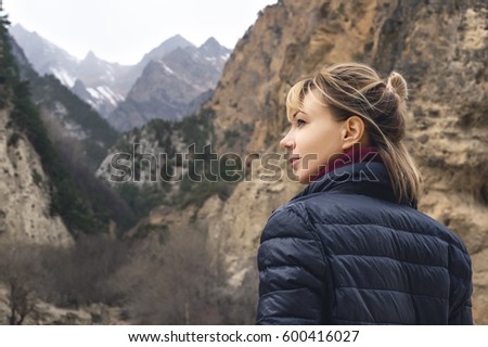 A beautiful girl photographer with a camera in the mountains
