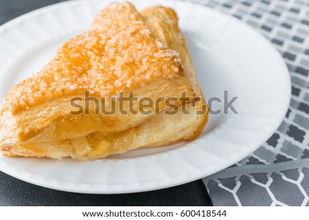 Apple turnover pastry on plate with gray napkin cloth