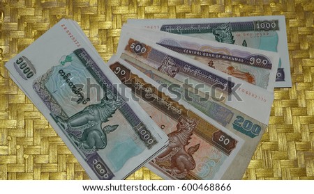 Myanmar kyat bank notes on gold tray. Royalty-Free Stock Photo #600468866