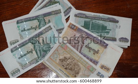 Myanmar kyat bank notes on wooden table. Royalty-Free Stock Photo #600468899