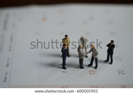 Miniature people: Two confident business man shaking hands during a meeting, success, dealing, greeting and partner concept.