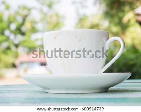 Coffee cup stains on wooden table and blurry garden background
