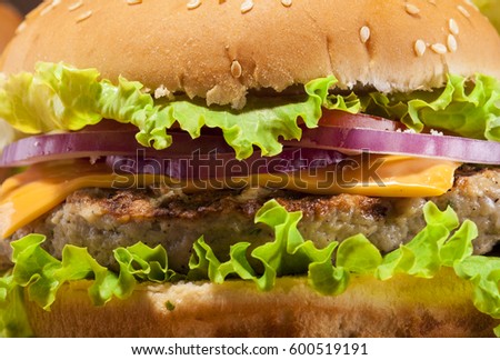 Close up of fresh delicious burger with meatball, cheese, onion and lettuce.