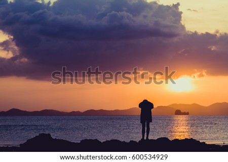 Siluate lonely man at the beach before sunset background