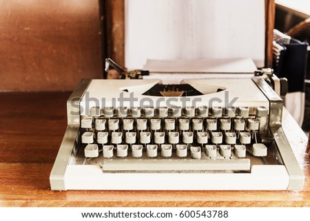 antique typewriter; old typewriter on wooden table, old technology; retro filtered.