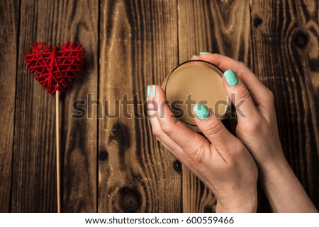 a woman hand bright manicure, cup of coffee, handmade heart