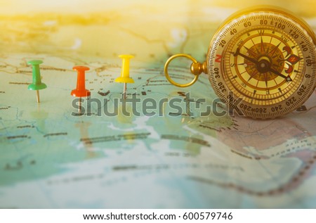 pins attached to map, showing location or travel destination and old compass. selective focus.