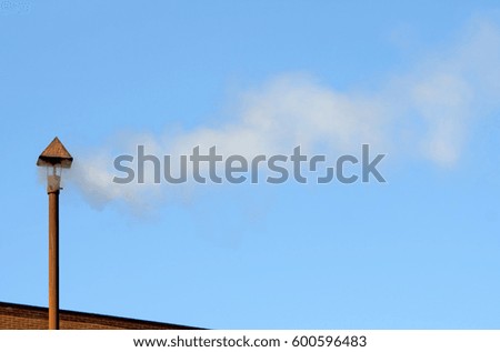 white smoke on a blue sky from a factory chimney