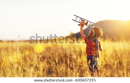 Child pilot aviator with airplane dreams of traveling in summer in nature at sunset

