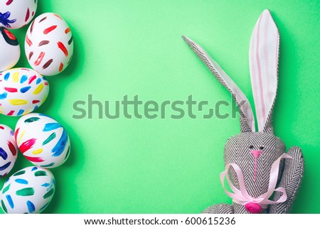 Easter bunny on a green background with Easter eggs. Rabbit. Space for text. 