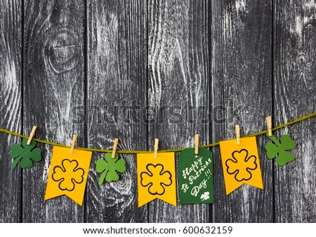 Happy St Patrick's Day card, March 17, Flags with attributes With shamrocks clover and card with massage "Happy Patricks day" on clothespins On the wooden table background