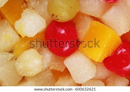 Fruit salad texture. Fruits as background pattern. Exotic Fruits  Fruit salad with cocktail cherry sour cherry mango pineapple grapes,pear,papaya in syrup.
