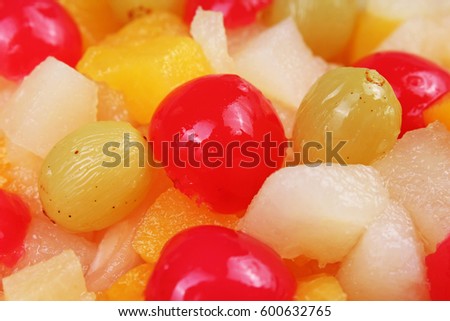 Fruit salad texture. Fruits as background pattern. Exotic Fruits  Fruit salad with cocktail cherry sour cherry mango pineapple grapes,pear,papaya in syrup.
