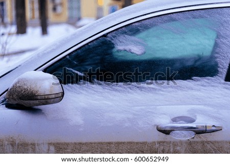 Close-up of snow-covered car wing mirror