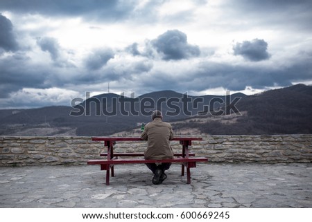 Man sitting at wooden table in public park