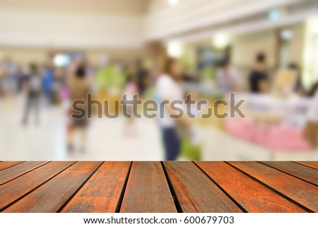 blurred image wood table and people in shopping mall with bokeh