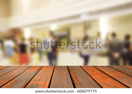blurred image wood table and people in shopping mall with bokeh