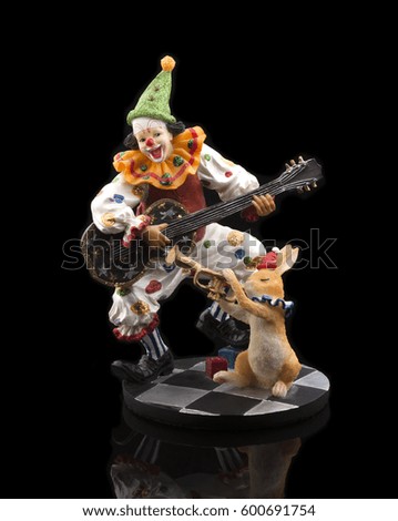 Clown in circus playing guitar for dog