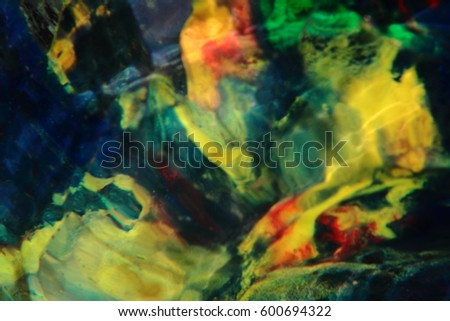 An Image of a Fantasy Blurred Pond Showing Water Ripples with Coloured Rocks and Stone. 