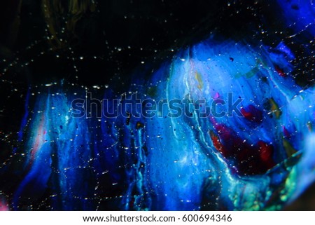 A Blurred Image of a Fantasy Dog Showing a Face and Body Behind a Pane of Glass with Droplets of Rain.