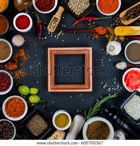 Large set of spices, herbs, vegetables and wooden photo frame on black background
