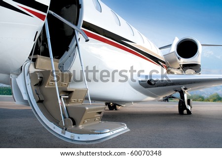 Business private jet with open stairs waiting for passenger, early morning, blue sky. Open door. Ready jet. Royalty-Free Stock Photo #60070348