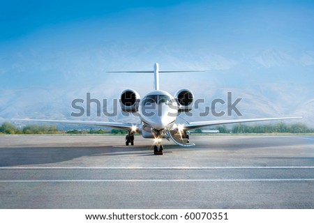Private jet airplane on airfield, waiting a passenger. Front view. Morning time. Blues sky horizon, Business and power concept. Royalty-Free Stock Photo #60070351