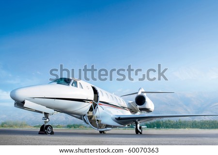 Business private jet airplane on airfield. Waiting a passenger with open door. Business and power concept. Royalty-Free Stock Photo #60070363