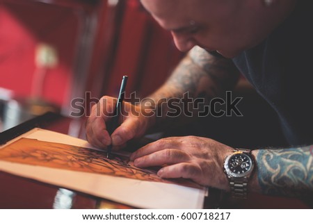 Process of making tattoo. Tattoo artist ends drawing that soon will become a tattoo