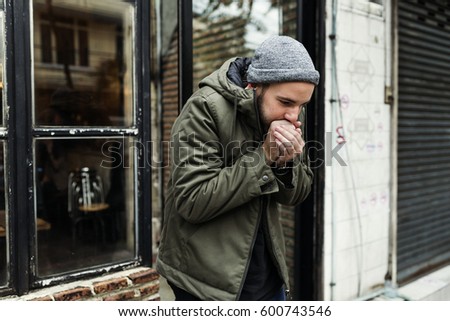 Guy Blowing his Hands in Cold Outdoor