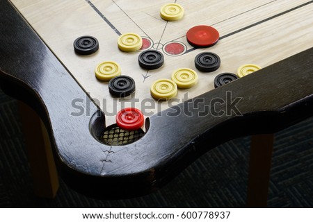A game of carrom with pieces carrom man on the board carom -