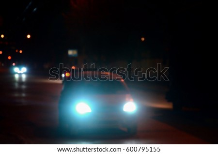 Nights lights of the big city, the blurred night avenue with bokeh traffic lights and headlights of the approaching cars