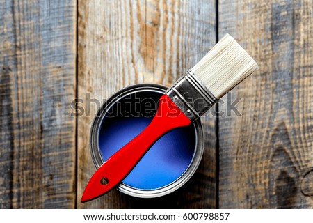 jar with blue paint on the wooden background top view