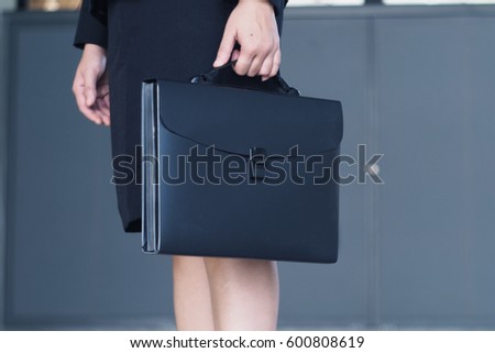Close up of business woman carrying briefcase.