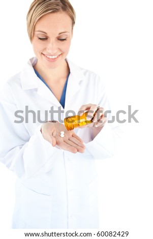 Charming young doctor holding pills against a white background