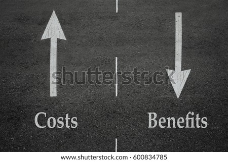 Opposite arrow on the asphalt road with text costs and benefits.