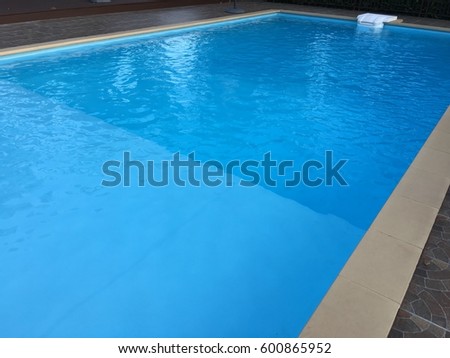Swimming pool with stair at hotel close up on top of roof deck building. Royalty-Free Stock Photo #600865952