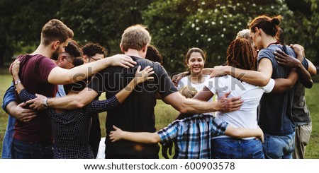 Group of people huddle together in the park Royalty-Free Stock Photo #600903578