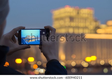 Man taking photo on her smartphone building in Moscow, Russia