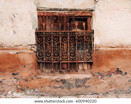 Decorative metal window on an old concrete wall.