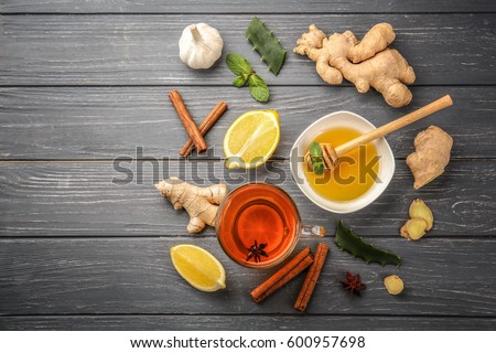 Hot drink with honey, lemon and ginger for cough remedy on wooden table Royalty-Free Stock Photo #600957698