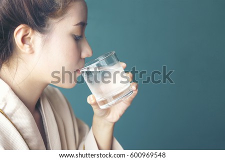 Young woman felling thirsty, drinking cold water after finished from hot sauna session at Spa Center - Spa Concept Royalty-Free Stock Photo #600969548